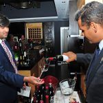 Jaime Mejia le sirve una copa de vino a Luis Laviosa