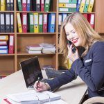 attractive woman in the office talking on phone and smiling