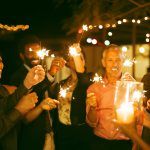 Friends playing with sparklers at party