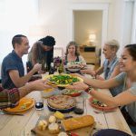 Friends passing food at dinner party