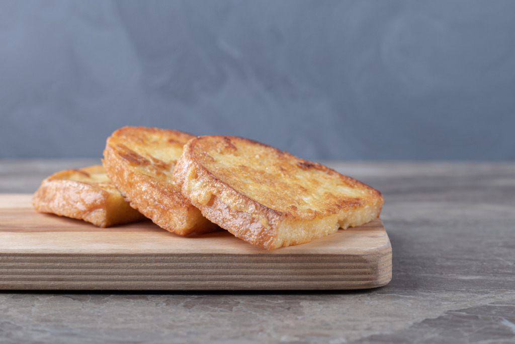 La torrija, entre tradición e innovación: el dulce español que conquista la Semana Santa 4 fried bread with egg wooden board