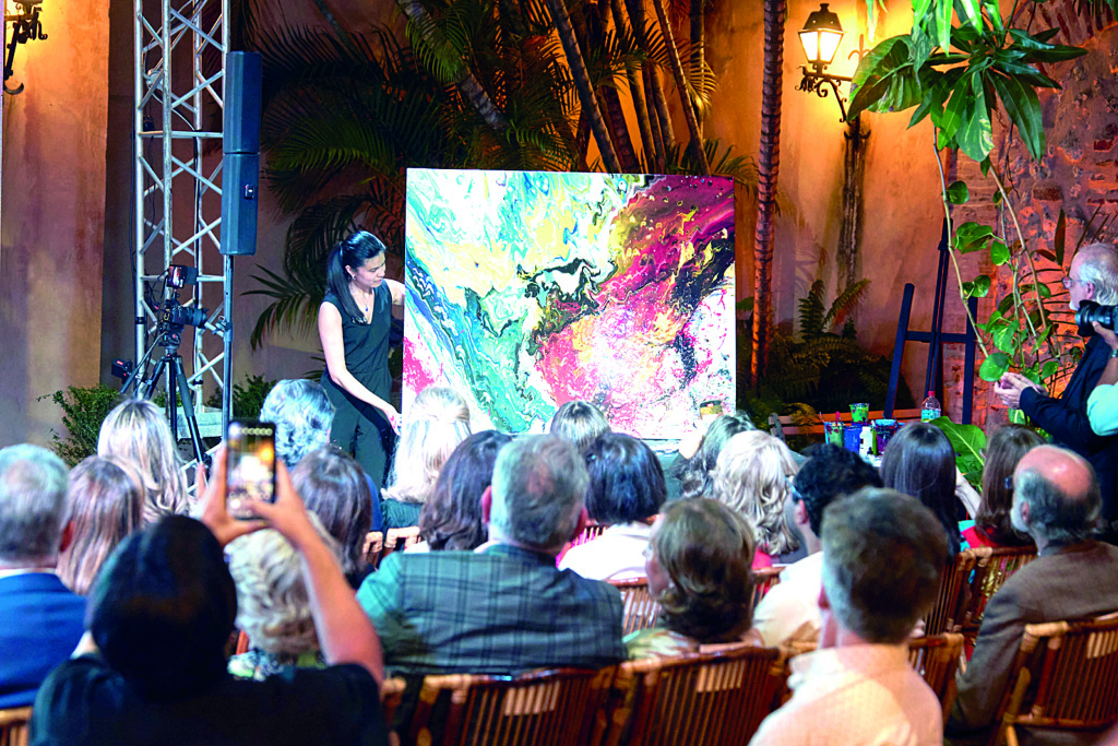 Charlotte Orcel mostrando la obra que creo frente a los asistentes del evento