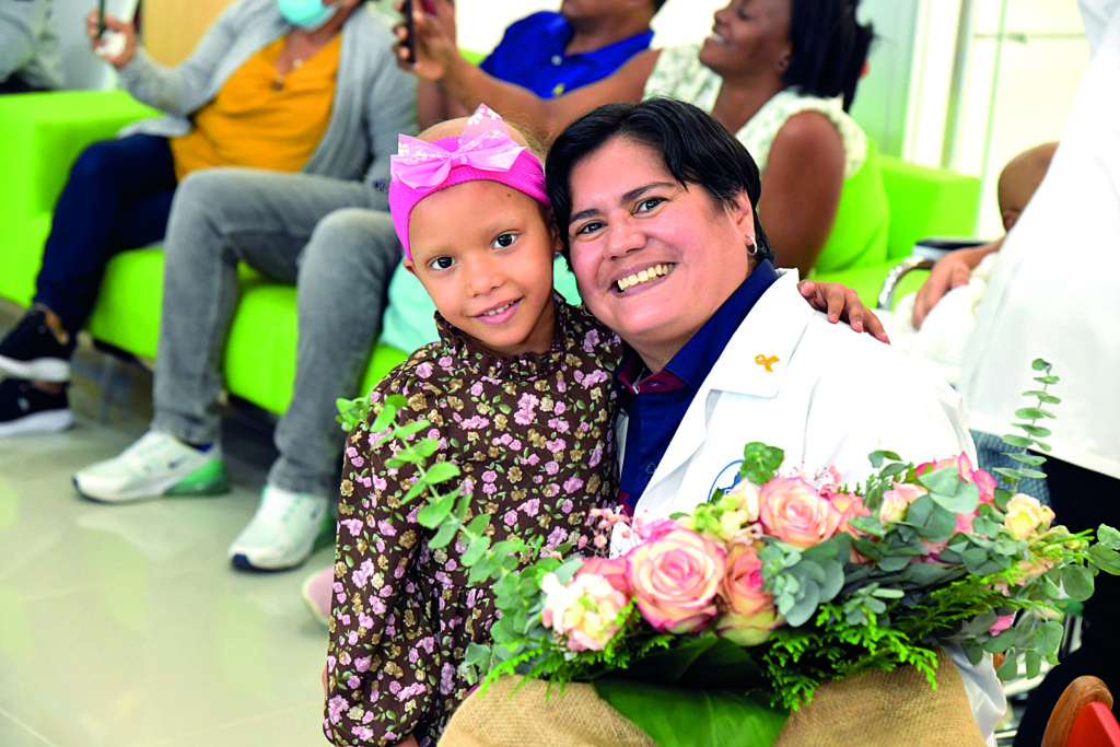 Dra. Wendy Gomez recibiendo un ramo de rosas de la mano de una de sus pacientes